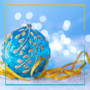 Blue Christmas Ornament with gold trim and a blue background with white lights.