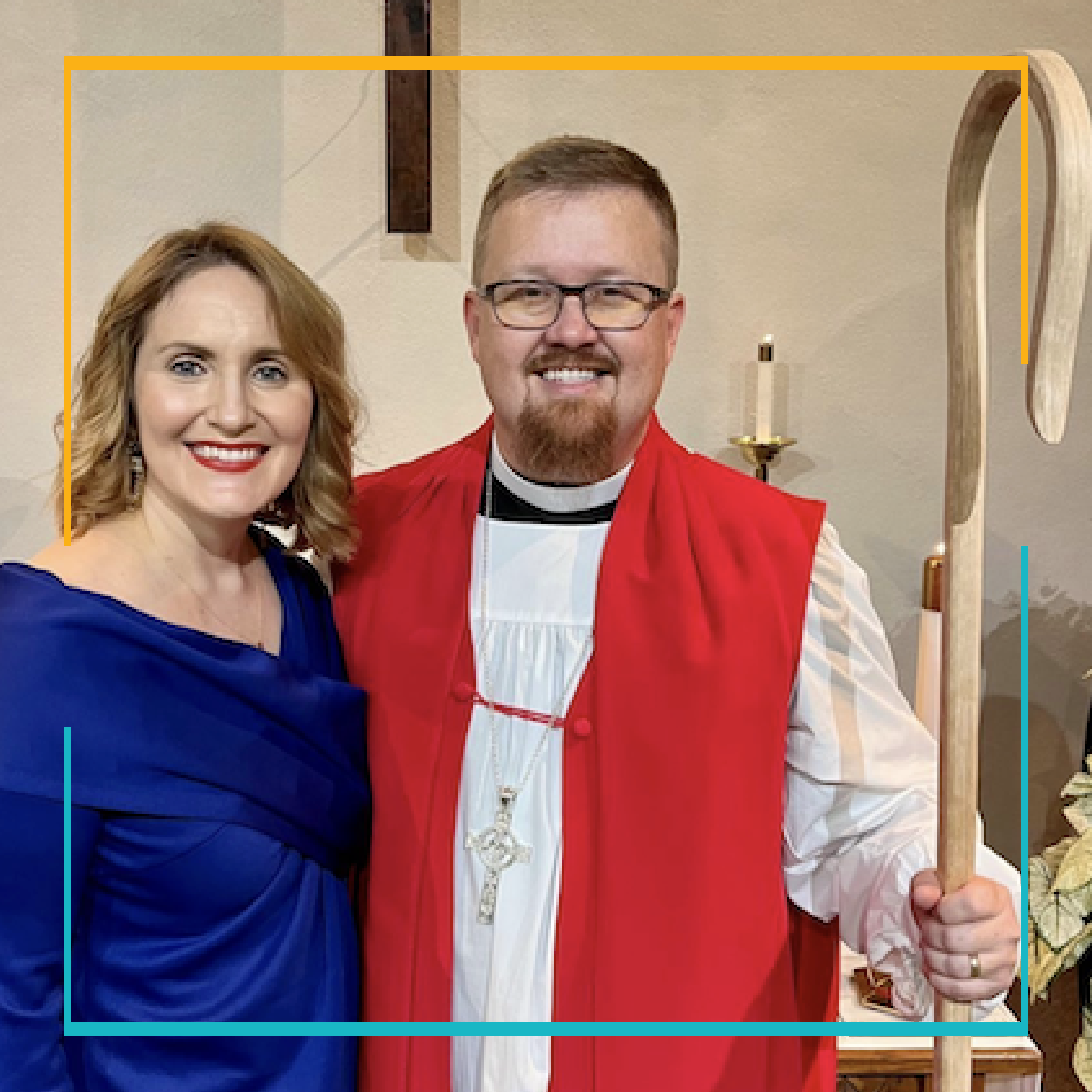 Bishop Jonathan standing with his staff, red vestment, next to his wife, Ivey in a bright blue dress